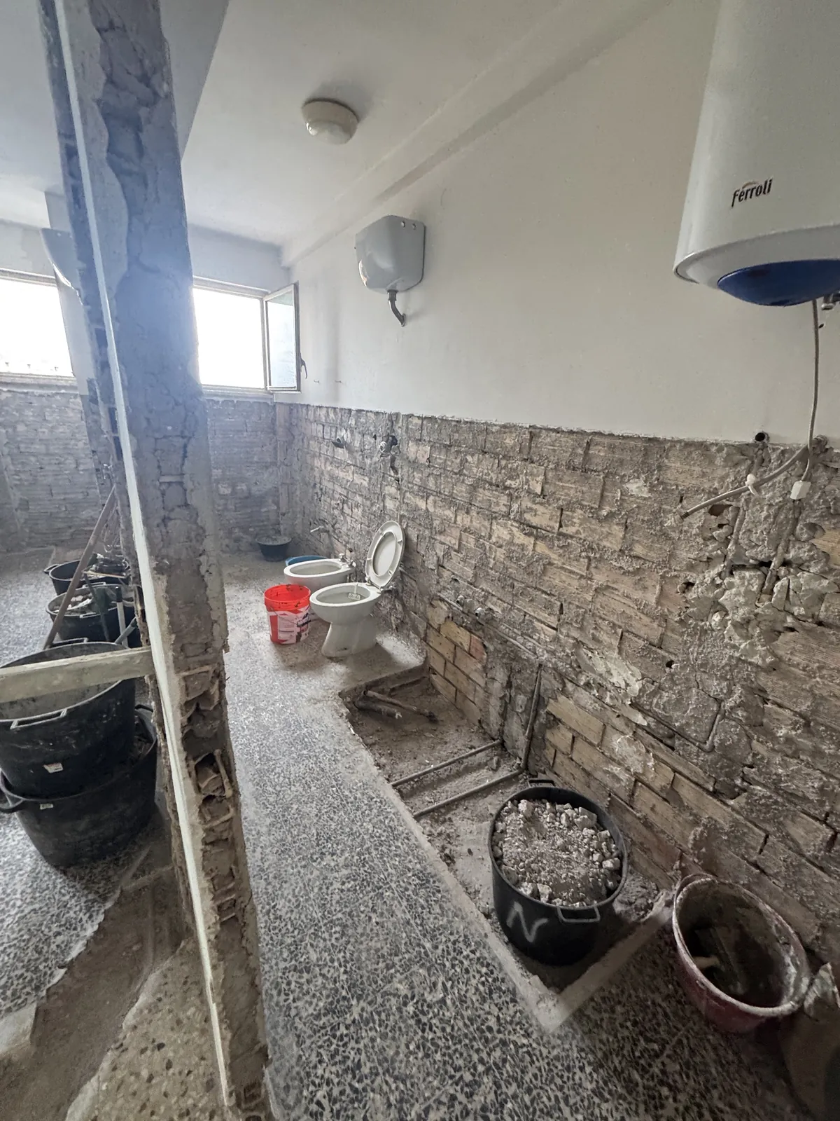 Bagno in demolizione con le pareti in muratura a vista